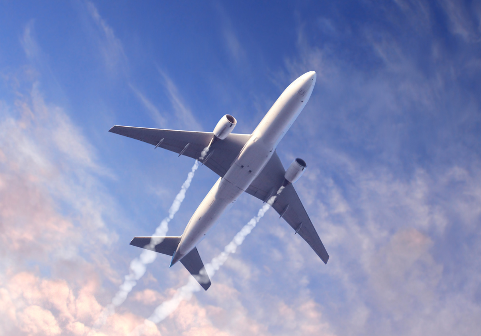 Airplane flying across the sky, viewed from below.