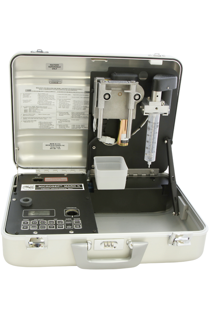 Open portable micro-separometer from Emcee with a digital display and keypad on the left, sample chamber and tubing on the right, set against a transparent background.