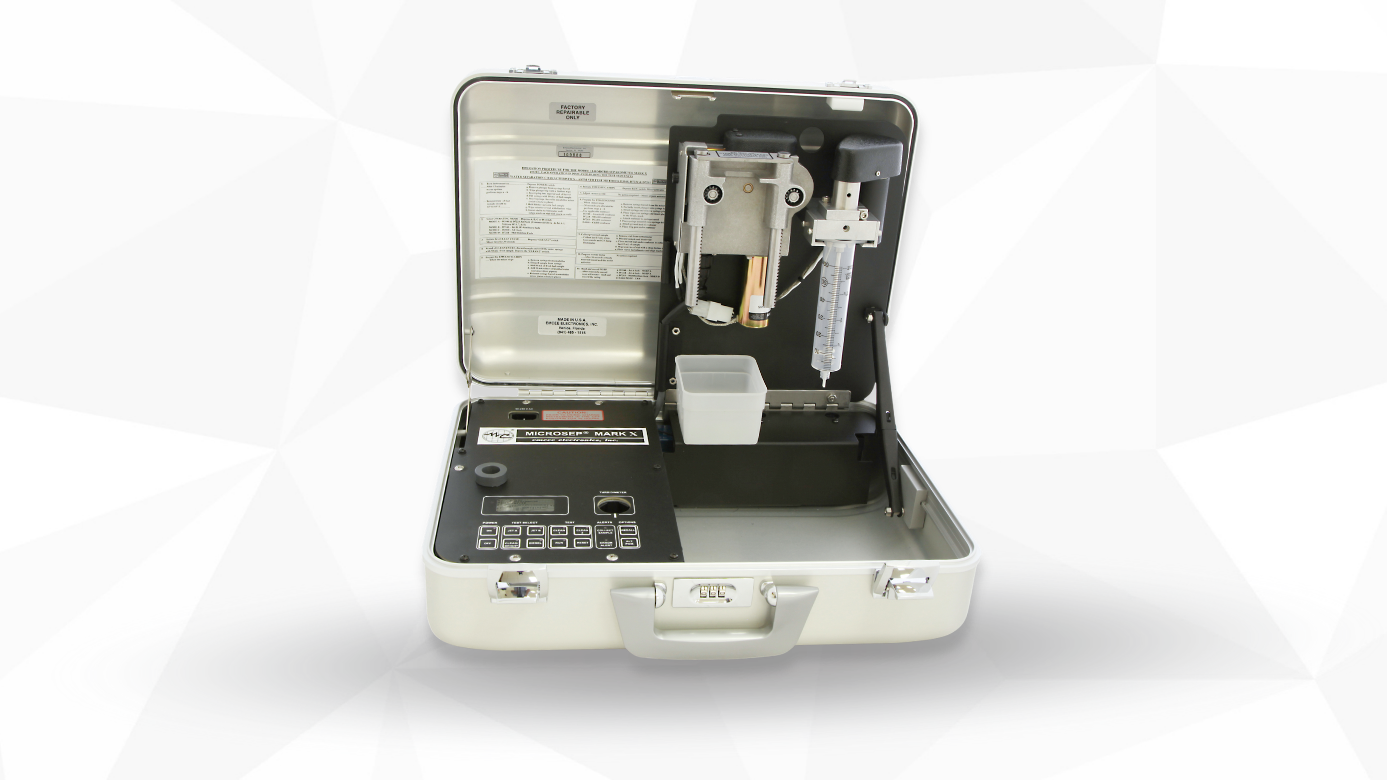 Emcee Model 1140 Micro-Separometer, a portable analytical instrument, open in a metal case with buttons and a small display on the left and mechanical components on the right, suggesting technical functionality.