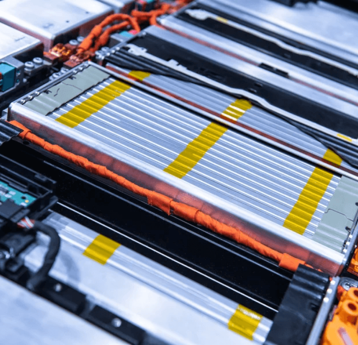 Close-up of a modern lithium-ion battery pack, showcasing metallic cells and orange wiring. The image conveys advanced technology and innovation.