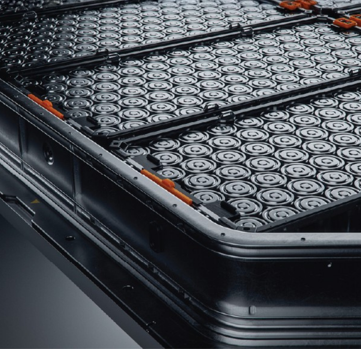 Close-up of an electric vehicle battery pack, displaying tightly packed cylindrical cells in a grid. The sleek, metallic components convey a sense of innovation.