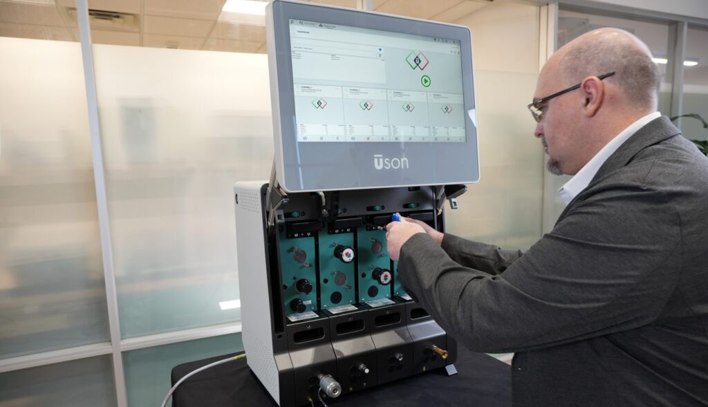 Meet a man working on a large laboratory Astra Dash device with a large display screen.