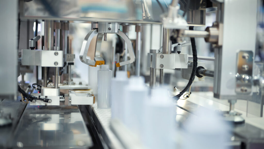 Automated packaging line filling small containers for pharmaceutical or cosmetic products. High-precision dispensing system designed for sterile production environments pharmaceutical filling, cosmetic packaging, automation, liquid filling line, precision machinery. meet.