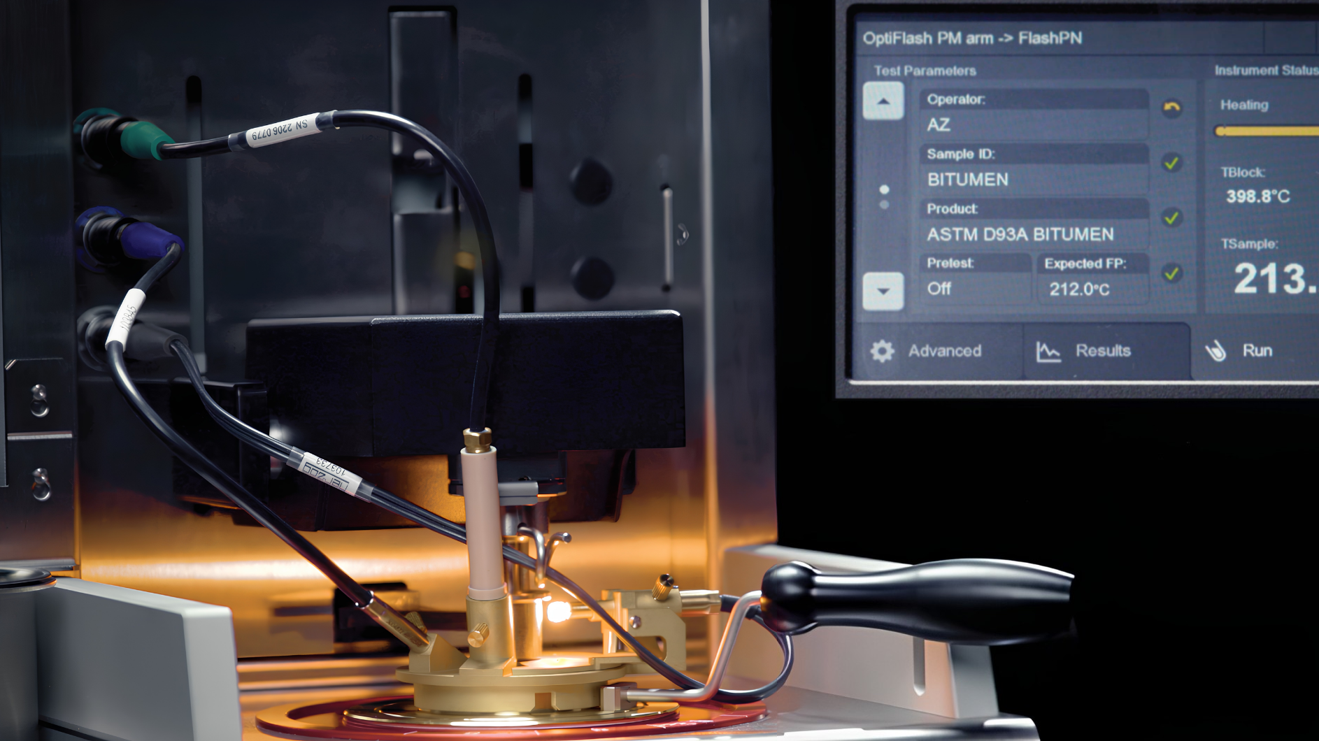 A laboratory testing instrument for material analysis, featuring a gold apparatus with connected cables, alongside a digital touchscreen displaying testing parameters and temperature readings. Flash Point Methods.